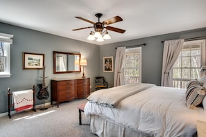 A bedroom with a bed, a dresser, a chair, a ceiling fan, and two windows with curtains. - Gooseberry House - Full 3 bedroom, 2.5 bath house rental across the road from Campground. Inculdes access to communal areas of campground including Nantahala River and self-guided farm tour. (Franklin)