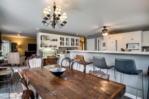 A dining area with a wooden table, chairs, and a chandelier. - Gooseberry House - Full 3 bedroom, 2.5 bath house rental across the road from Campground. Inculdes access to communal areas of campground including Nantahala River and self-guided farm tour. (Franklin)