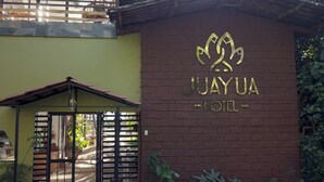 The entrance to the Juayua Hotel with a metal gate and a brick wall. - Hotel Juayua (Juayua)