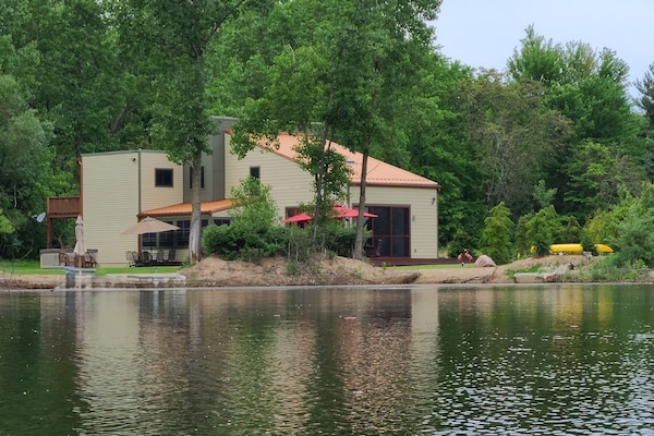 Nestled on a private community lake with 200' of lakefront on 4 wooded acres