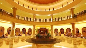 A spacious, multi-level atrium with a central fountain, columns, and seating areas. - Luxurious Penthouse Suite on the Ridge or Beachfront side- Playa Grande Resort  (Cabo San Lucas)