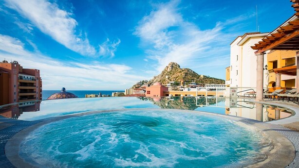 A hot tub with a view of the ocean and a mountain in the background. - Luxurious Penthouse Suite on the Ridge or Beachfront side- Playa Grande Resort  (Cabo San Lucas)