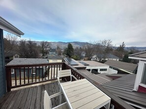 Ein Wohngebiet mit mehreren Häusern, einer Holzterrasse und Blick auf ferne Berge.