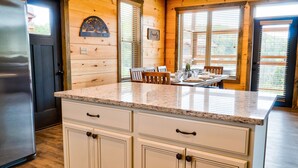 A kitchen with wooden walls, a granite countertop, and a stainless steel refrigerator. - Smokey Mnt. Getaway w/Hot Tub, Deck + Amazing view (Sevierville)