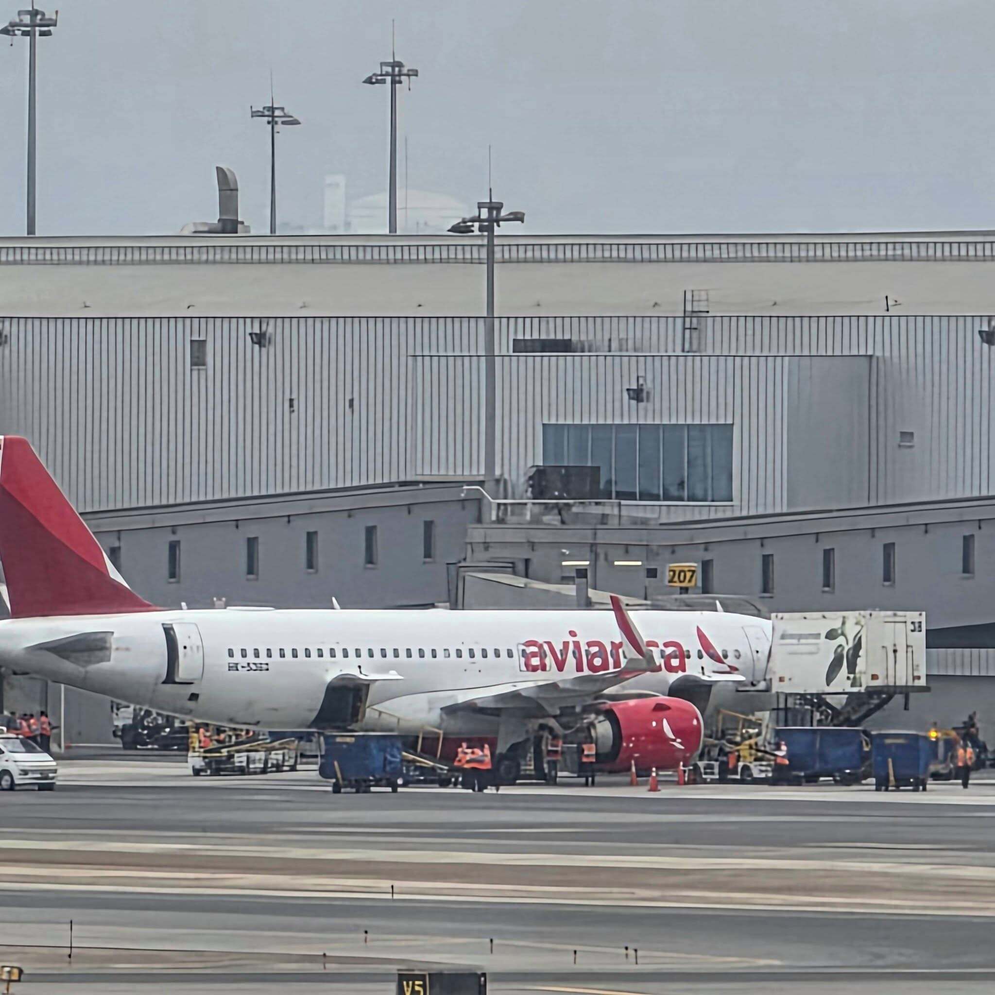An airport terminal with a large airplane parked on the tarmac.