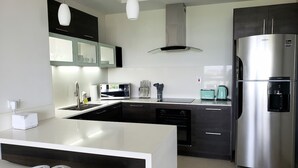 A modern kitchen with a stainless steel refrigerator, a microwave, and a toaster. - 24/7 Security, 2B/R Paradise w/Infinity Rooftop Pool & City Views 🌴🏊 (Kingston 10)