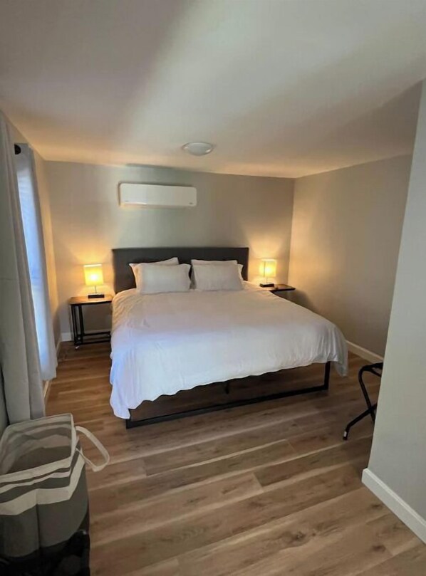 Simple, stylish accommodations with a single bed, bedside tables, and a comfortable chair.