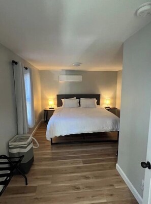 Relax in a serene space with a large bed, bedside tables, and a comfortable chair.