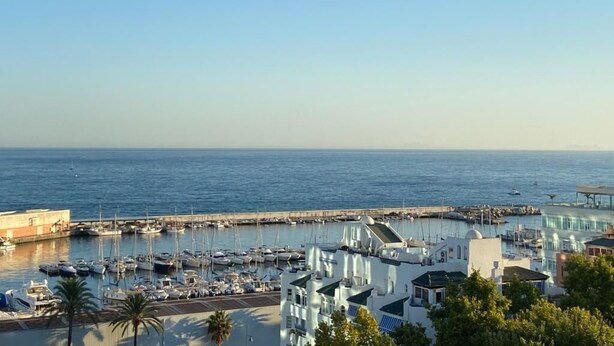 A marina with boats, a pier, and buildings with a clear view of the sea. - Duplex penthouse facing the sea (Marbella)