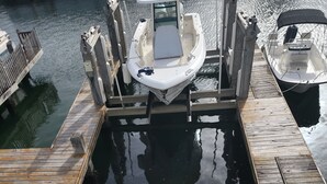 A boat docked at a pier with a tiled deck and a potted plant. - North Finger Private Villa in Paradise (Jolly Harbour)