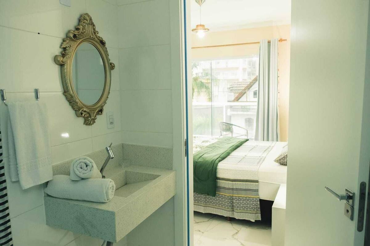 A bathroom with a sink, mirror, and towel rack.