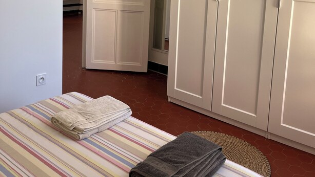 A room with a bed, a wardrobe, and a door leading to another room. - Detached villa in residential area, beach and shops nearby (Sanary-sur-Mer)
