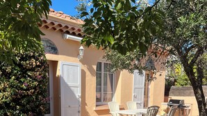 A patio area with a tiled floor, white chairs, and a table. - Detached villa in residential area, beach and shops nearby (Sanary-sur-Mer)