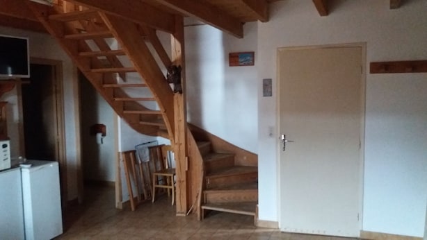 Un escalier avec des rampes en bois menant à une porte.