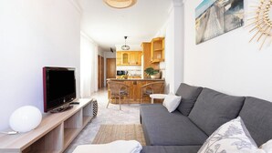 A modern living room with a grey sofa, a flat-screen TV, and a woven light fixture. - Home2Book Caletillas Breeze & Comfort (Tenerife)