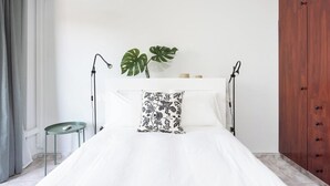 A bedroom with a bed, a small table, a plant, and a wardrobe. - Home2Book Caletillas Breeze & Comfort (Tenerife)