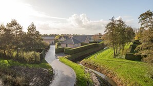 Un quartier résidentiel avec des maisons, une rue étroite et un ruisseau.