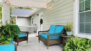 A covered porch with wicker furniture and potted plants. - Greer Twin Cottage A - Walk to City Park and Downtown Greer (Greer)