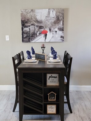 Una mesa de comedor preparada con platos, servilletas y un cartel que dice "FOOD & FRIENDS".