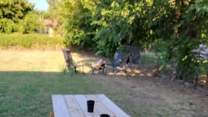 Una mesa de picnic de madera con dos bancos y dos tazas negras encima.
