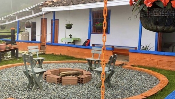 Un espace patio aménagé avec un foyer, des sièges et des jardinières suspendues.