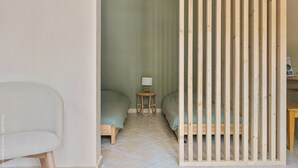 A room with two beds, a small table with a lamp, and a chair. - Large apartment with terrace and pool view (La Bouilladisse)