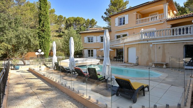 A two-story building with a swimming pool, outdoor seating, and a covered patio area. - Large apartment with terrace and pool view (La Bouilladisse)