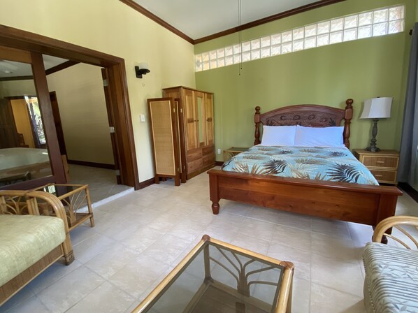 Un dormitorio con una cama de madera, una mesita de noche, un armario y una silla.