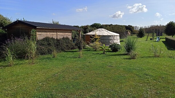 A wooden cabin and a covered yurt in a grassy field with trees in the background. - Studio in a chalet (Bourlon)
