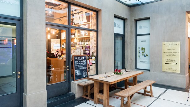 Ein Restaurant mit einem großen Schaufenster, das Weinflaschen und eine Speisekarte zeigt.