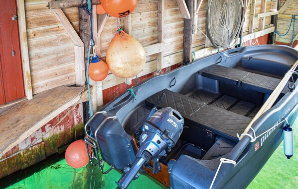 A small boat with a Yamaha outboard motor, a fishing net, and orange buoys.