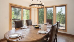 Une salle à manger avec une grande table en bois, six chaises et un lustre.
