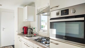 A modern kitchen with a gas stove, oven, and a coffee maker. - Beautiful home in Giethoorn with WiFi (Giethoorn)