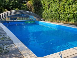 Surrounded by lush greenery, this pool offers a serene escape with a clear water surface and a wooden deck.