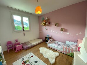 Cozy child's retreat with a bunk bed, shelf for toys, and a view of the surrounding landscape.