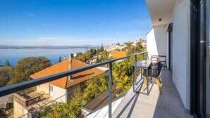 Un balcone con vista su un lago e edifici circostanti.
