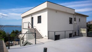 Un edificio moderno e bianco con una scala che conduce a una terrazza sul tetto.