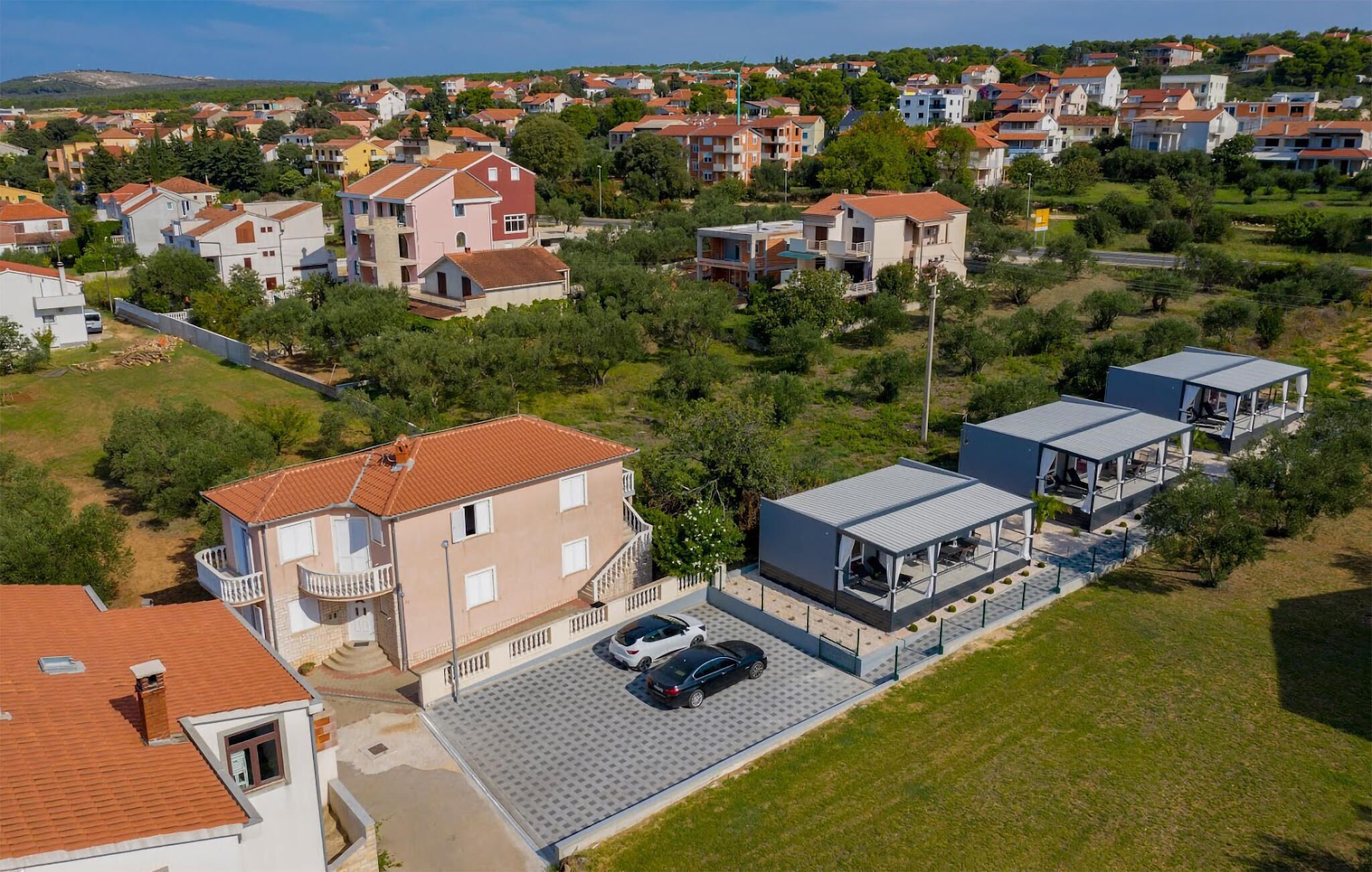 Zona residencial con casas, piscina y aparcamiento.