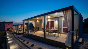 Un edificio moderno con paredes de vidrio, asientos exteriores y un área de patio.