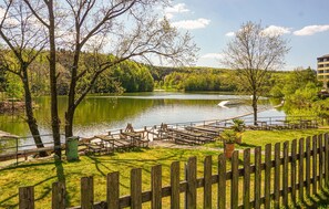 A lakeside park with picnic tables and a wooden deck. - Ferienhaus 109 in Kirchheim (Kirchheim)