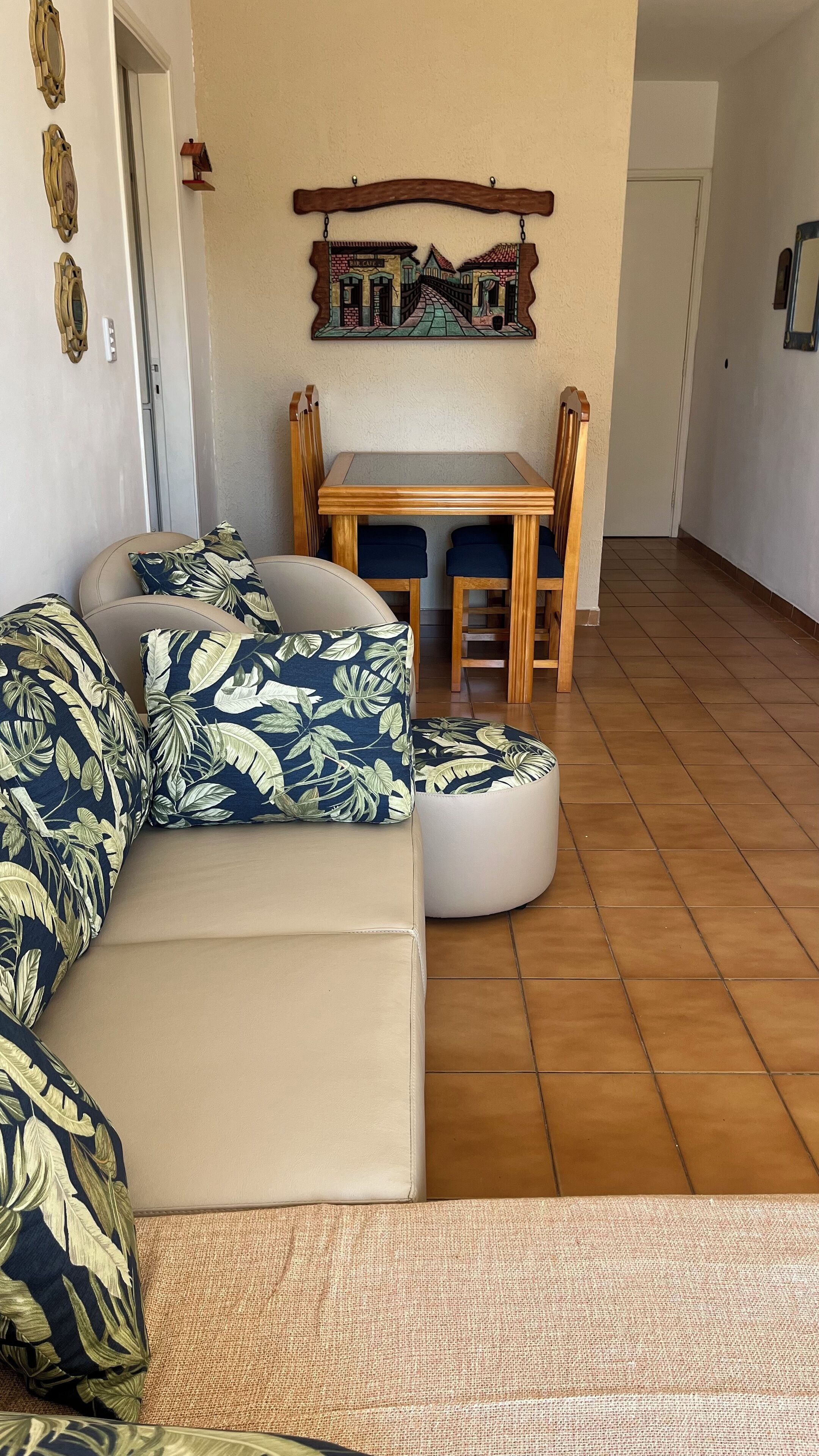 A living room with a beige sofa, a wooden dining table, and a wall-mounted picture.