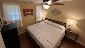 A bedroom with a bed, ceiling fan, bedside lamps, and a nightstand. - On Lake Dardanelle, quiet but close to town (Dardanelle)