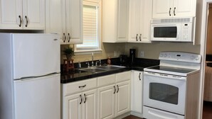 A kitchen with white cabinets, a refrigerator, a microwave, a stove, and a sink. - On Lake Dardanelle, quiet but close to town (Dardanelle)