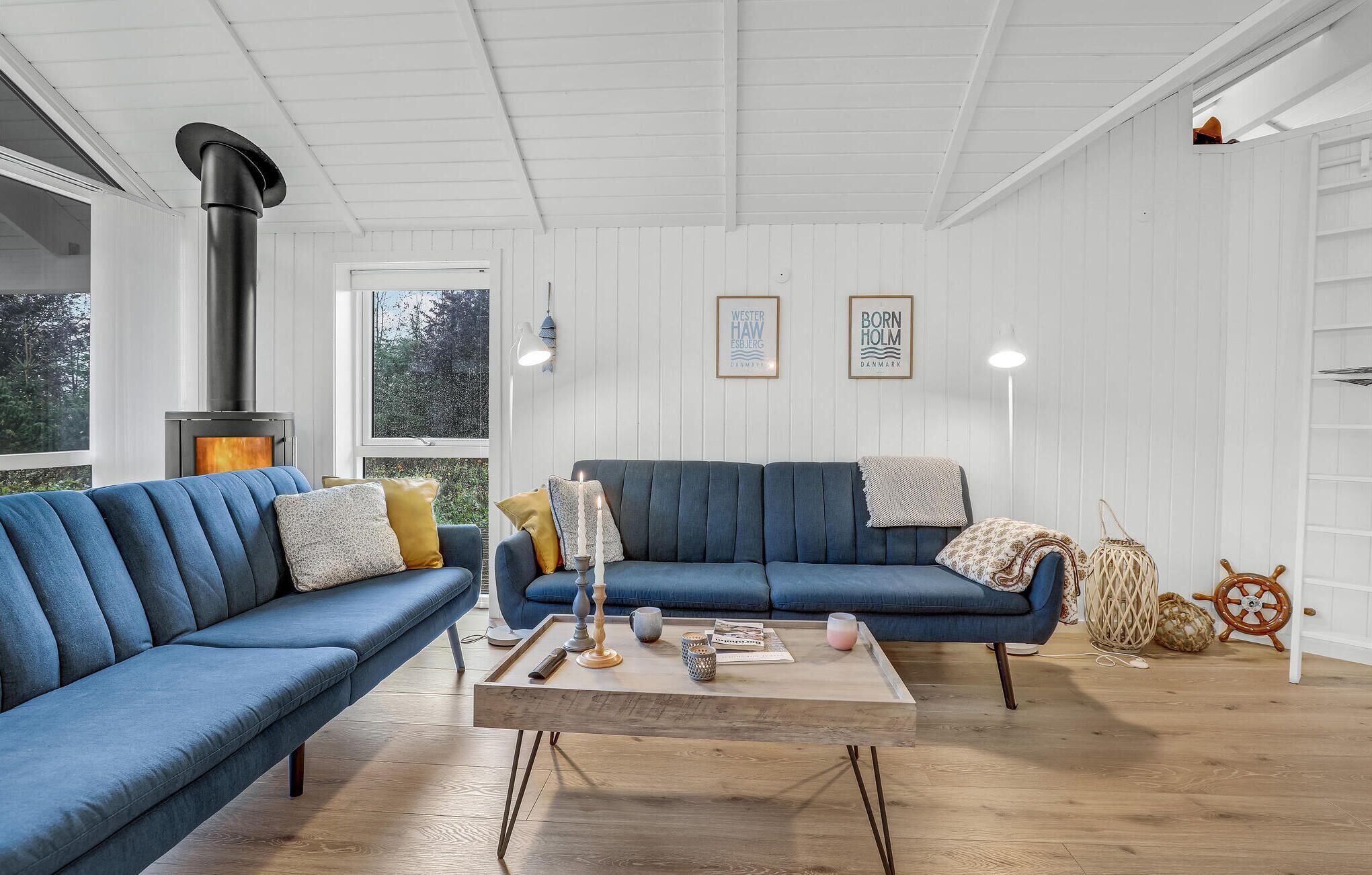 A cozy living room with a blue sofa, a wooden coffee table, and a fireplace.