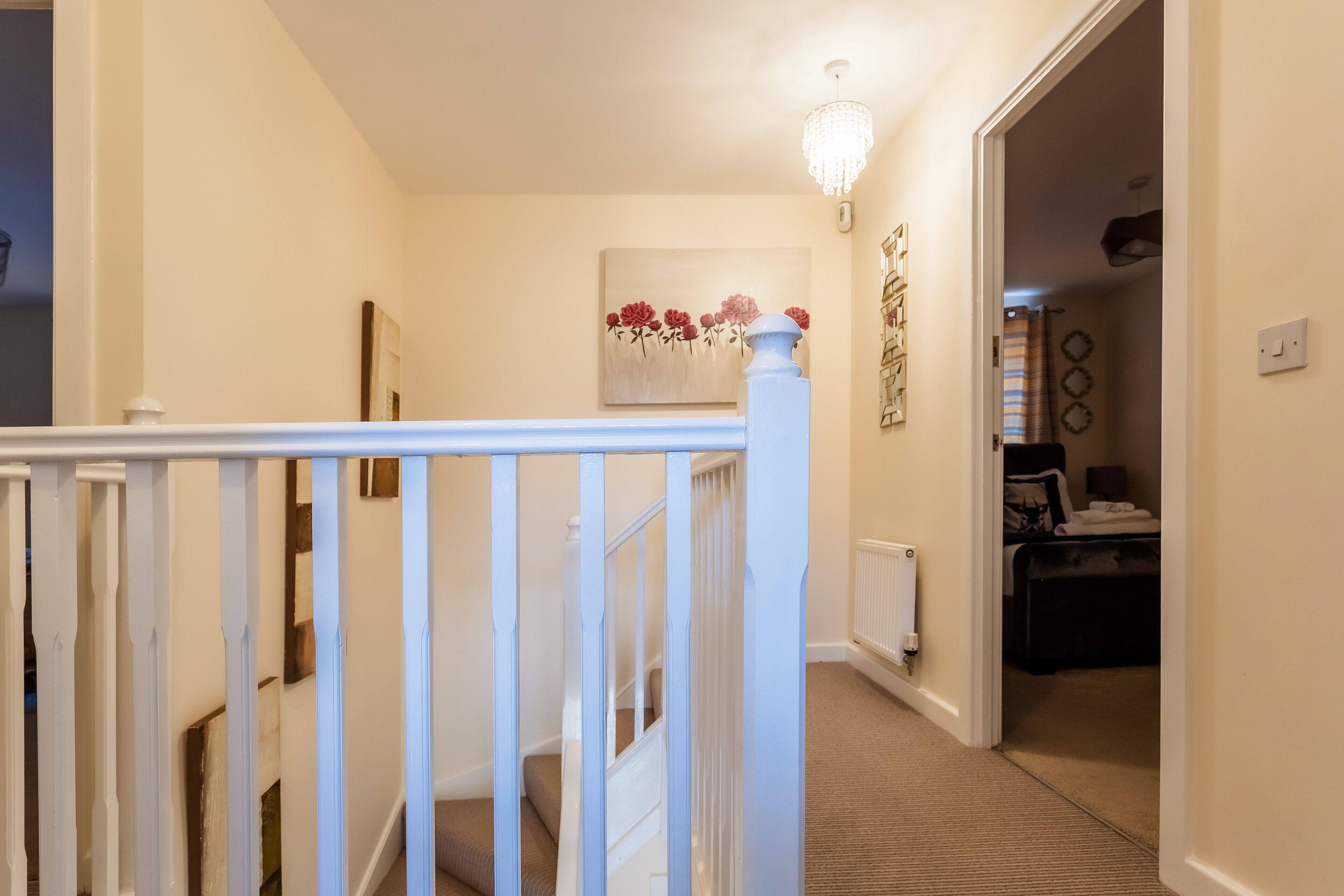 Un couloir avec un escalier menant à une chambre.
