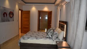 Ein Schlafzimmer mit einem großen Bett, einem Nachttisch und einem Duschbereich.