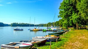 Une jetée au bord du lac, où sont amarrés différents types de bateaux le long de la rive.