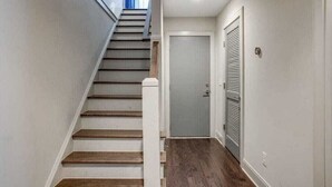 A staircase with wooden steps leading to a door with a metal shutter. - Stunning Nashville Retreat - Near Broadway (Nashville)