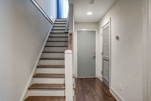 Eine Treppe mit Holzhäusern, die zu einer Tür mit Rollo führt.