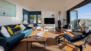 A modern living room with a sofa, armchairs, a coffee table, a fireplace, and a TV. - Seagrass - Dog Friendly-Hot Tub-Sea Views-Sleeps 4 (Ventnor)